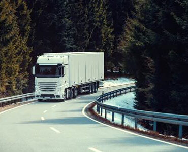 Pianotransport: Lkw fährt auf einer kurvigen Straße durch den Wald