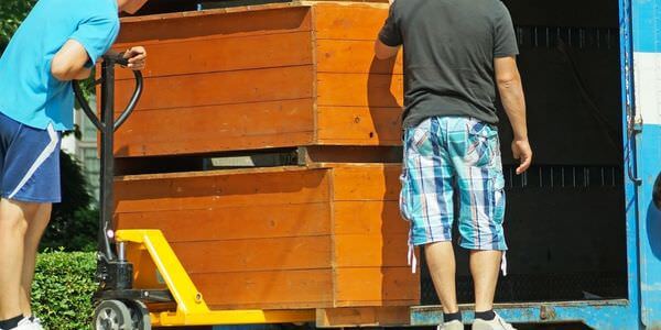 Möbellift Gießen: Zwei Helfer tragen einen Holzschrank aus einem Lkw